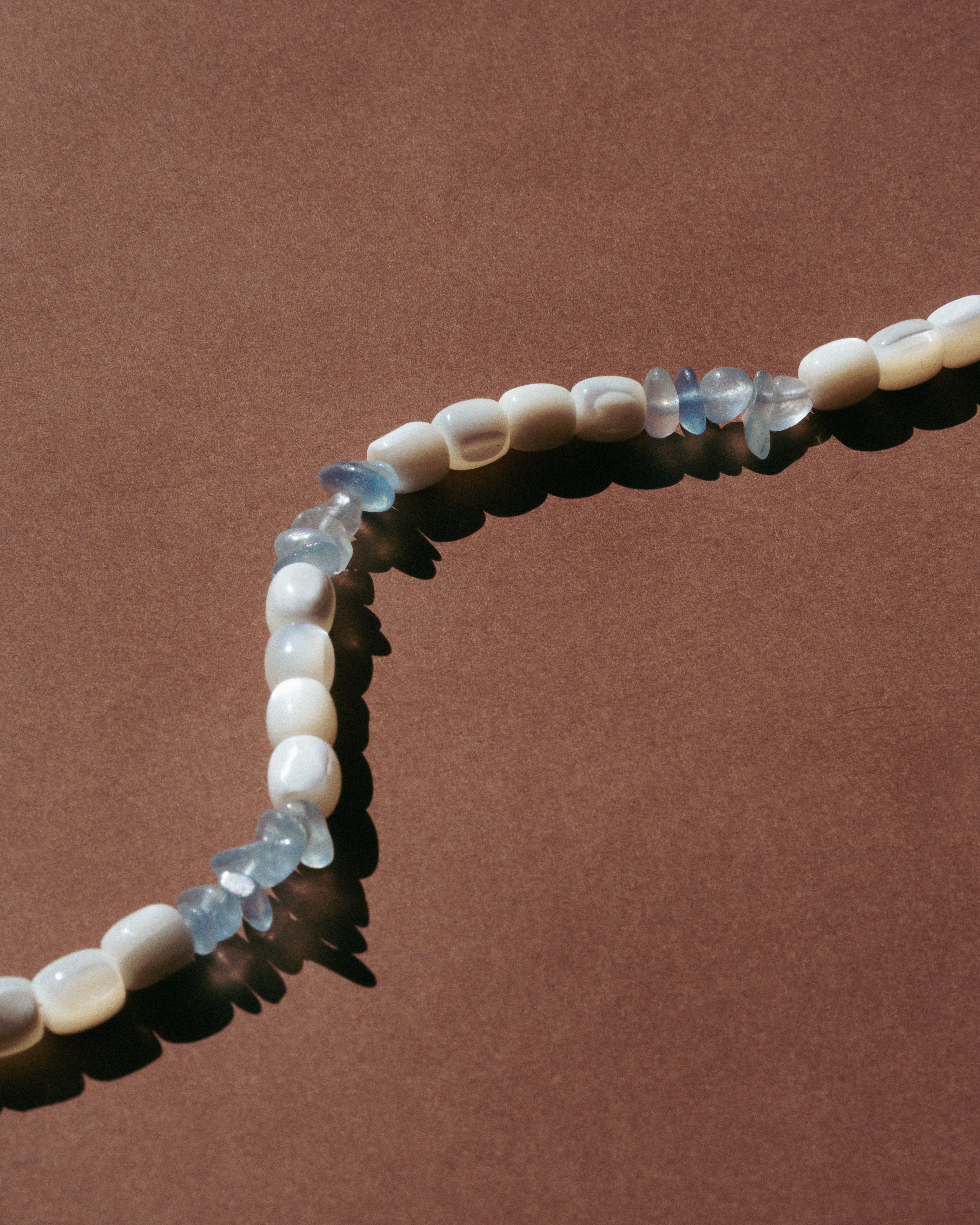 Upclose detailed unisex necklace with white and blue beads 