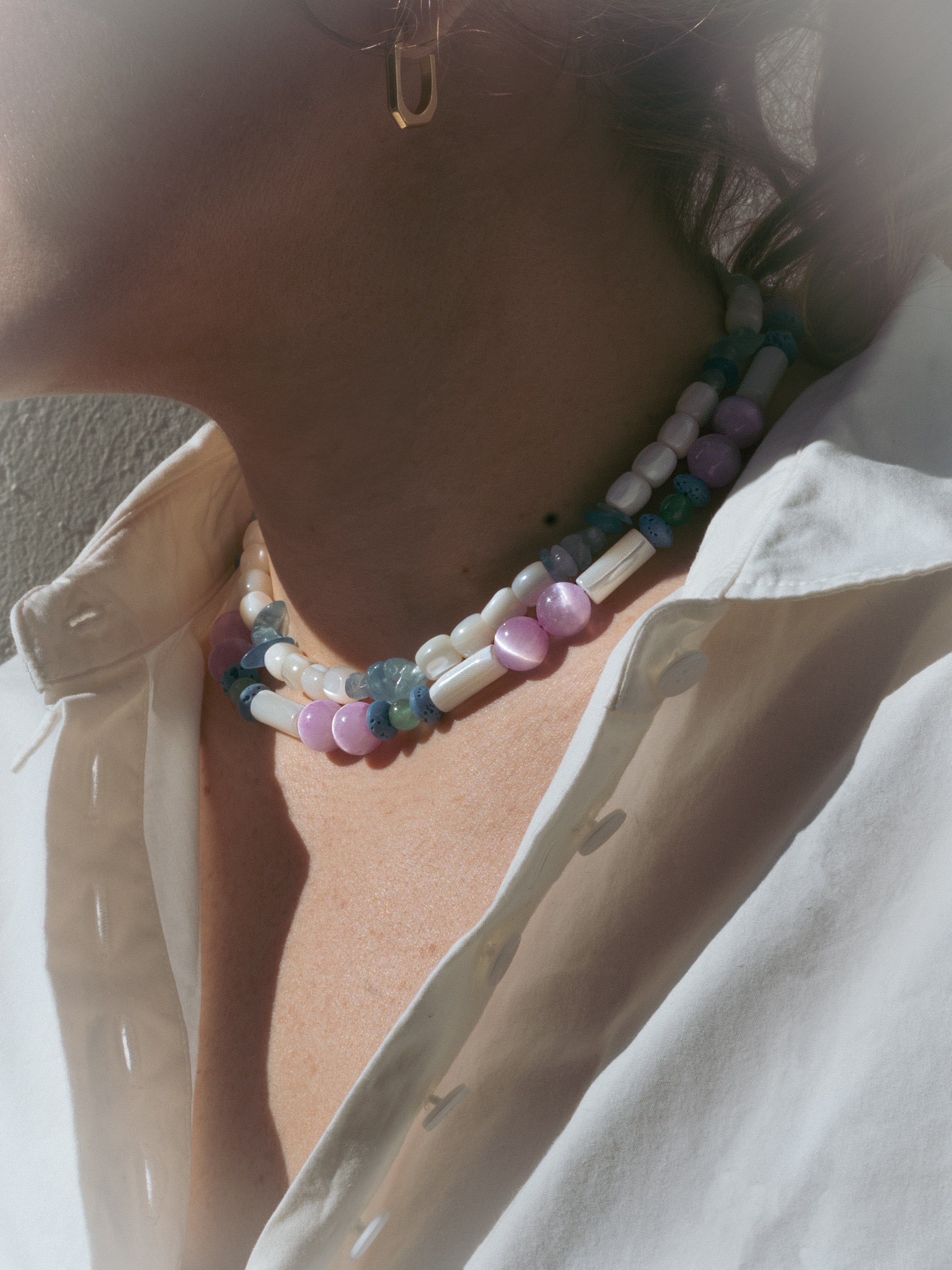 Close-up of a person wearing a colorful beaded necklace unisex