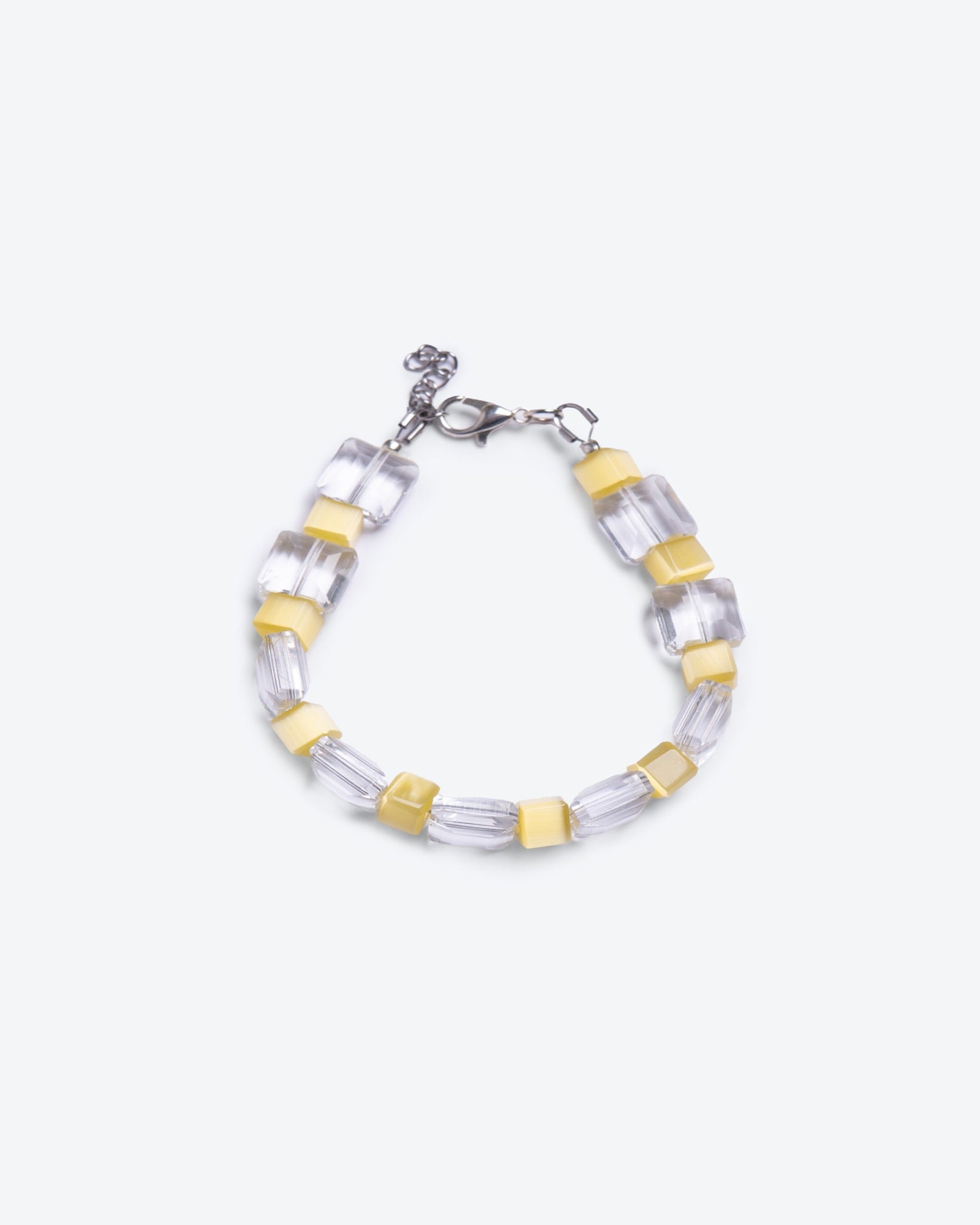 Unisex bracelet with clear glass and yellow cat's eye beads on a white background