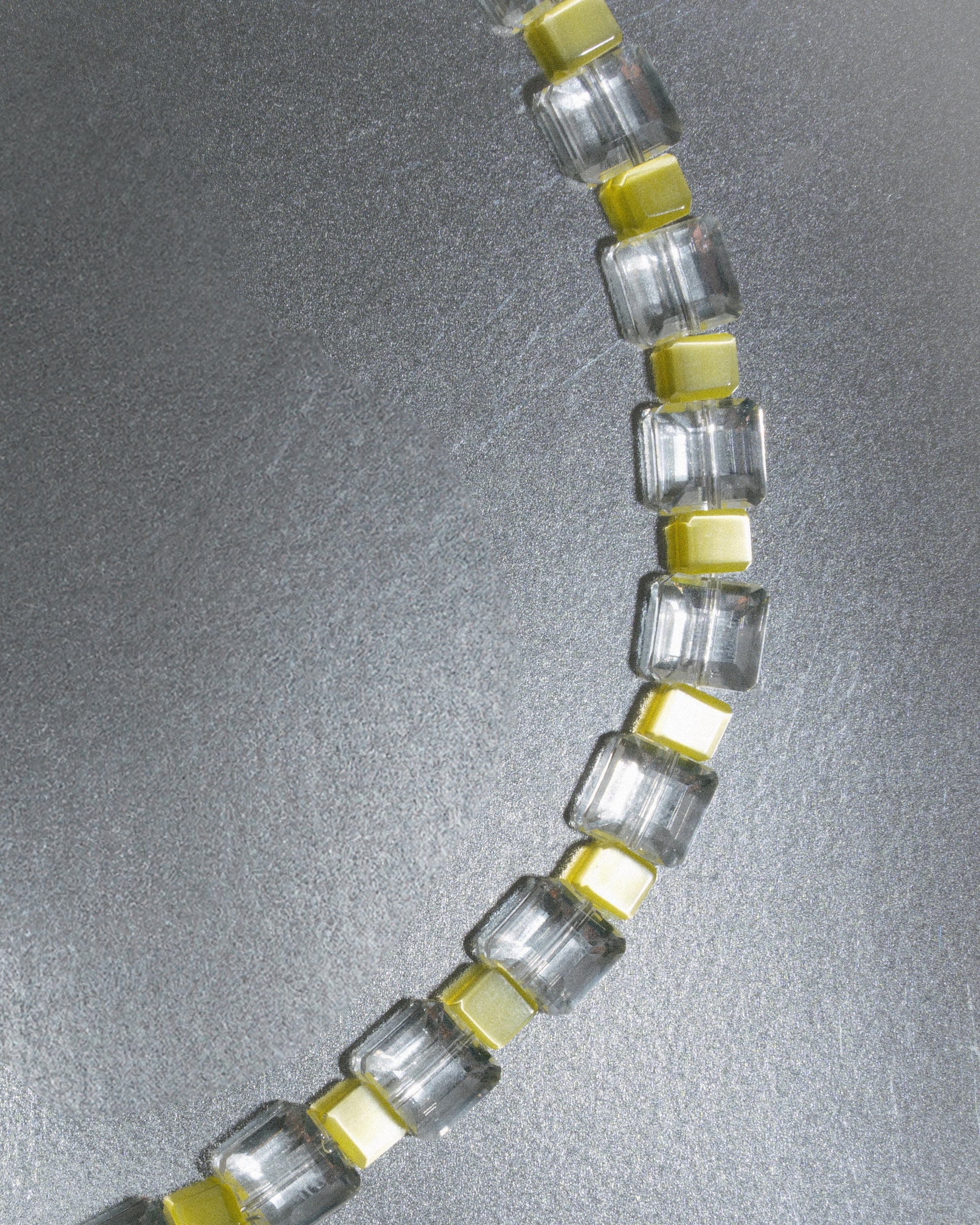 Close-up of a bracelet with clear and yellow glass gemstones unisex