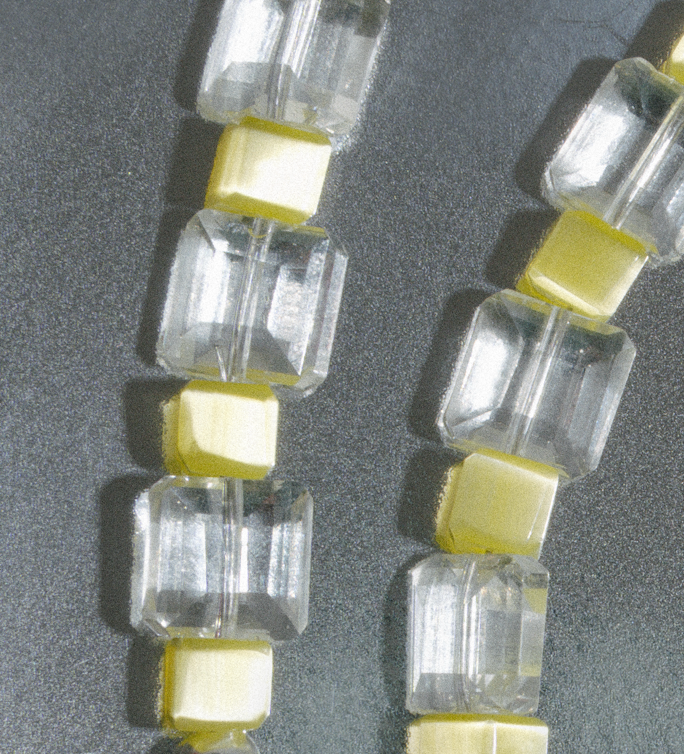 Close-up of a string of clear and yellow glass gemstones unisex